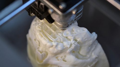 3D printer prints the form of molten plastic white close-up. Automatic three dimensional 3d printer performs plastic modeling in laboratory. Progressive modern additive technology